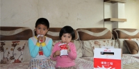 15日，乌鲁木齐市沙依巴克区扬子江路汇月社区学龄前小朋友领到工作人员专门送来的牛奶欣喜万分。胡宝军 摄 - 人民网