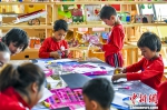 6月16日，新疆阿克苏市多浪第一幼儿园美工坊里，当日恰逢父亲节，孩子们在老师的指导下手工制作贺卡作为礼物送给父亲。 中新社记者 刘新 摄 - 中国新疆网