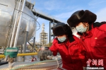 新疆油田采气一厂克拉美丽气田两名技术干部正在现场查看自动化运行情况。　王涛 摄 - 中国新疆网