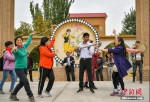 图为新疆疏附县吐万克吾库沙克村的乐器制作艺人们聚在一起，为游客弹奏乐曲。 - 中国新疆网