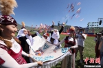 在草原上，遇到喜事，哈萨克族群众撒方糖、奶疙瘩等分享快乐。图为开幕式上的“恰秀”。　阿尔达克 摄 - 中国新疆网